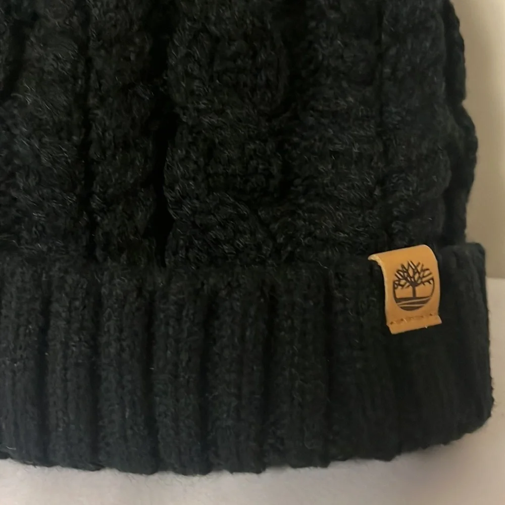 Timberland black cable knit, fleece lined hat with furry Pom on top, new